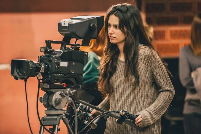 A videographer with camera on shoulder